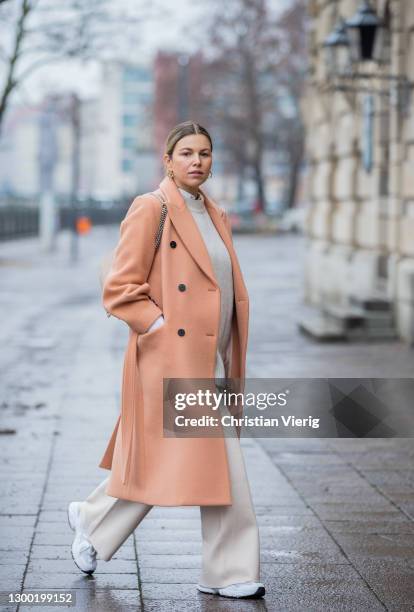 Aline Kaplan is seen wearing salmon colored coat, NOIR, pullunder: Zara, wide leg pants Reserved, white sneakers New Balance, YSL bag on February 03,...