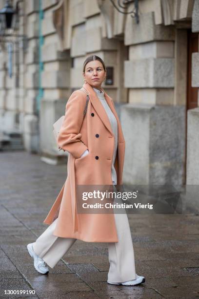 Aline Kaplan is seen wearing salmon colored coat, NOIR, pullunder: Zara, wide leg pants Reserved, white sneakers New Balance, YSL bag on February 03,...