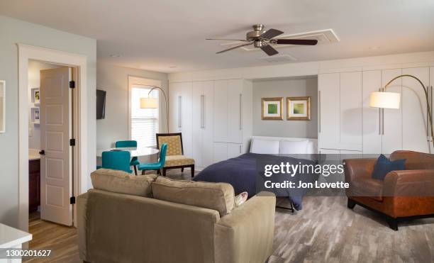 small apartment with murphy bed in built in storage unit - murphy bed stock pictures, royalty-free photos & images