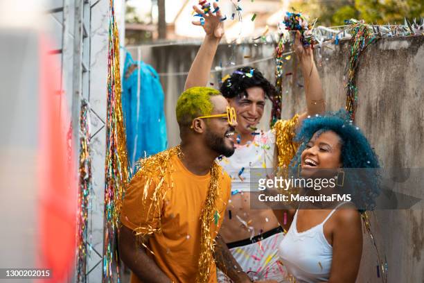 revelers mit bemalten haaren tanzen karneval - straßenfest stock-fotos und bilder
