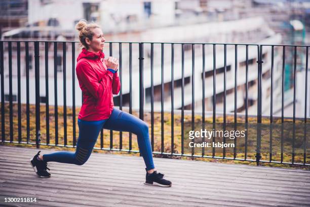 sporty woman exercising at terrace. - hip stock pictures, royalty-free photos & images