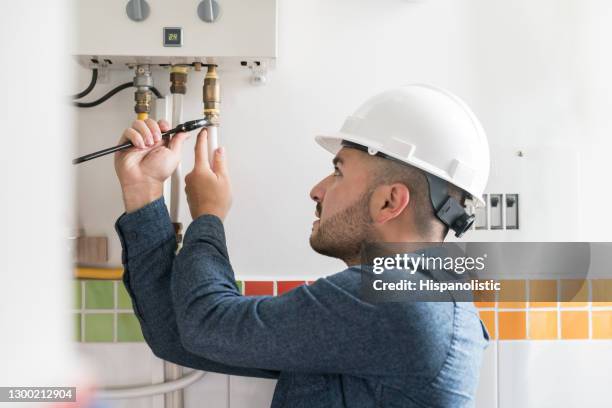 reparaturmeister installiert einen erdgaskessel in einem haus - water heater stock-fotos und bilder