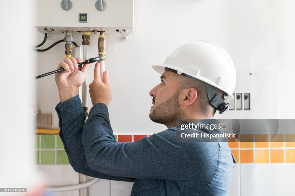 Repairman installing a natural gas boiler at a house