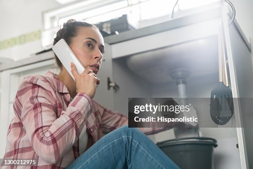 家裡的女人給水管工打電話, 說水槽裡水管漏水 家裡的女人給水管工打電話, 說水槽裡水管漏水