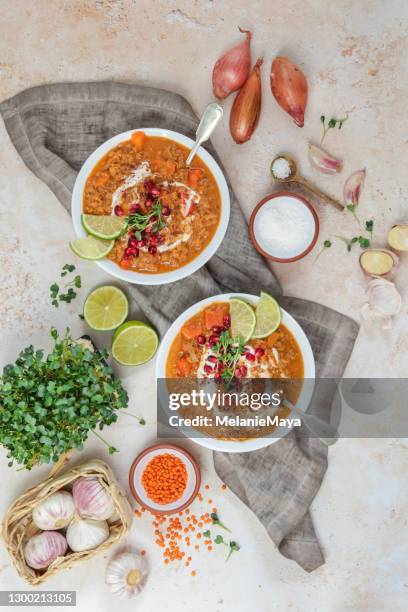 vegane marokkanische linsensuppe in schalen mit granatapfel serviert - flatlay stock-fotos und bilder