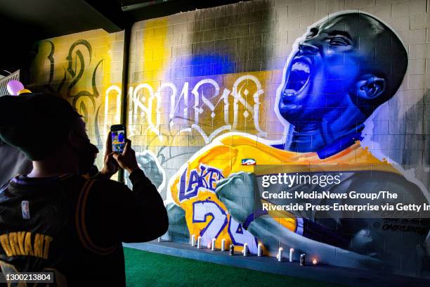 People pay their respects at a mural honoring the late Kobe Bryant at the Downtown Experiment in Riverside on Tuesday, Jan. 26, 2021. Bryant, his...