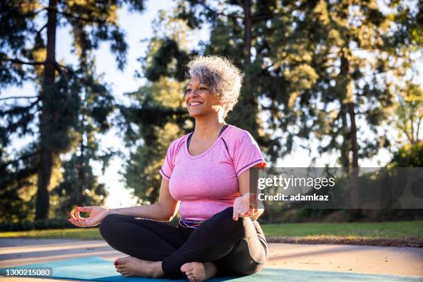 beautiful black woman meditating yoga - fat old women stock pictures, royalty-free photos & images