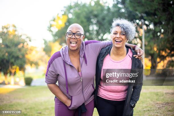 two black woman walking through a grass field - fat lesbian stock pictures, royalty-free photos & images