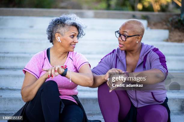 two black woman relaxing after workout - computador utilizável como acessório imagens e fotografias de stock