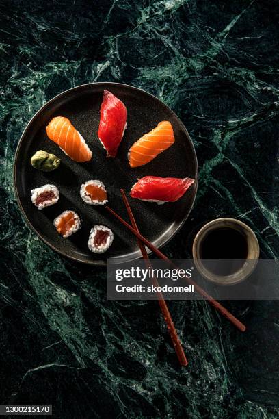 salmon and tuna sushi with soy sauce over green marble background - sashimi imagens e fotografias de stock