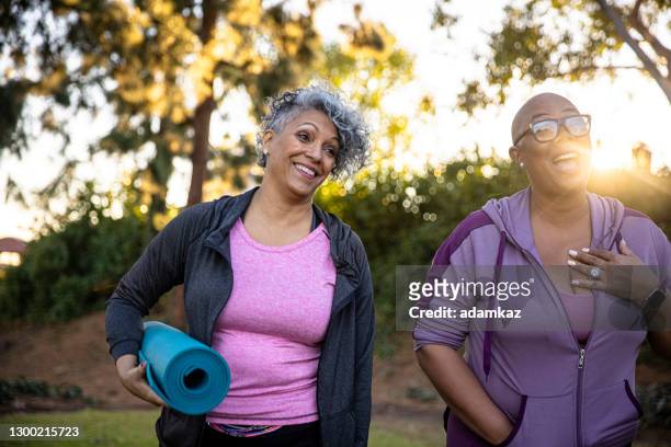 black friends walking away with her yoga mat - fat people stock pictures, royalty-free photos & images