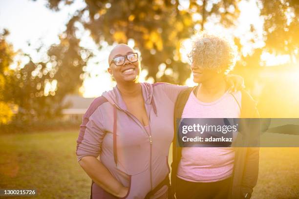 twee zwarte vrouw die door een grasgebied loopt - fat lesbian stockfoto's en -beelden