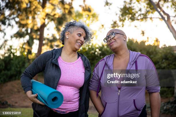 zwarte vrienden die weg met haar yogamat lopen - fat lesbian stockfoto's en -beelden