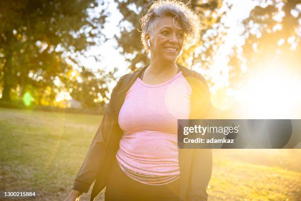 black woman walking in the sunset - senior spirituality stock pictures, royalty-free photos & images