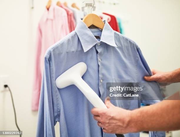 unrecognizable male steaming a dress shirt - steamer stock pictures, royalty-free photos & images