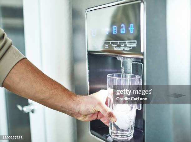 onherkenbare mens die glas van de dispenser van het koelwater vult - water cooler stockfoto's en -beelden