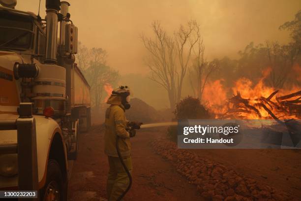 In this handout image provided by Department of Fire and Emergency Services, firefighters attempt to contain a bushfire in Wooroloo on February 2,...