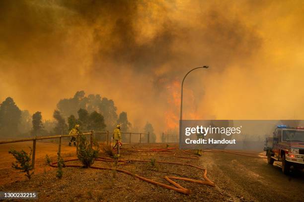 In this handout image provided by Department of Fire and Emergency Services, firefighters attempt to contain a bushfire in Wooroloo on February 2,...