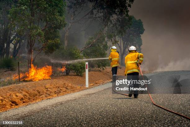 In this handout image provided by Department of Fire and Emergency Services, firefighters attempt to contain a bushfire in Wooroloo on February 2,...