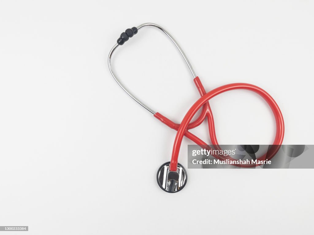Red Colour Stethoscope on white background with copy space - health care and medical concept.