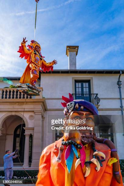 Mardi Gras Indian statue is lifted into a yard by crane to be placed next to a bust of New Orleans musician Dr. John on February 03, 2021 in New...