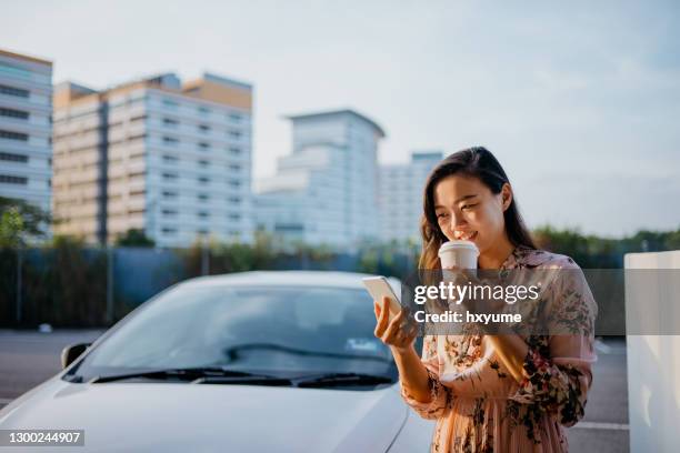 asian woman using phone and drinking coffee in the morning - takeaway coffee cup stock pictures, royalty-free photos & images