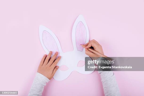 child's hands painting rabbit's mask for easter celebration. - rabbit mask fotografías e imágenes de stock