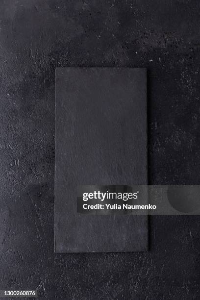 black slate stone cutting board on wooden background - カチンコ ストックフォトと画像