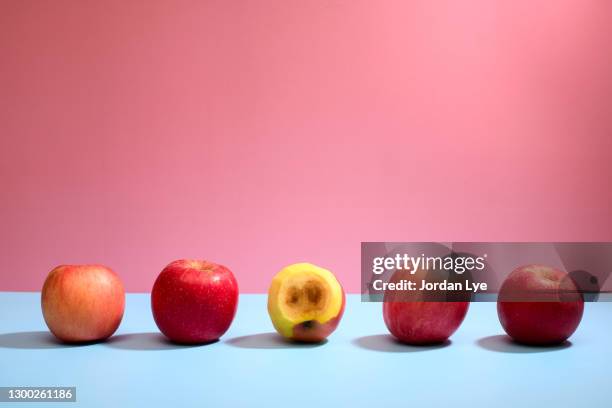 rotten apple among good ones in a row - apple rot stock pictures, royalty-free photos & images