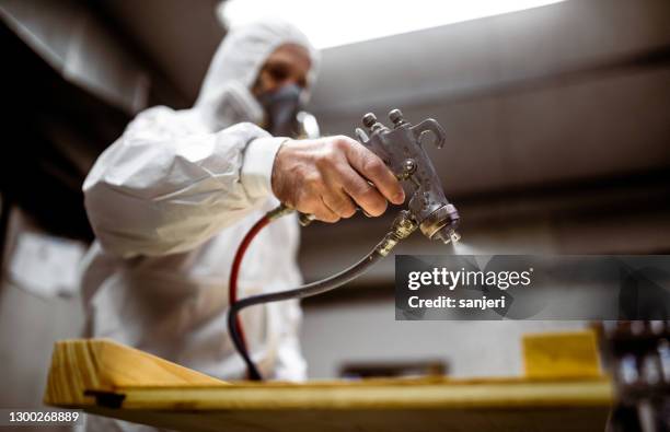 carpenter painting wood with spray gun - spraying paint stock pictures, royalty-free photos & images