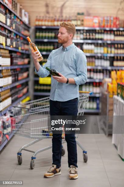 man choosing wine in liquir store - choosing wine stock pictures, royalty-free photos & images