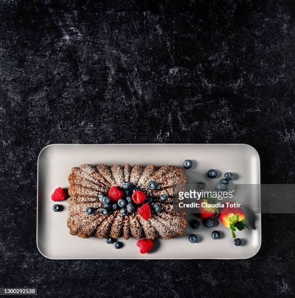 banana bread with berries on a tray on black background - square cake stock pictures, royalty-free photos & images