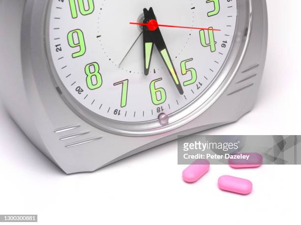 pills by alarm clock - tomada de decisão imagens e fotografias de stock