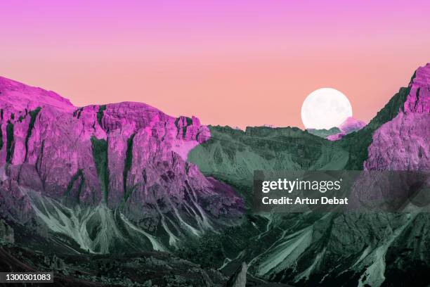 dreamy colorful picture of the dolomites mountains with vivid colors and full moon. - pink moon stock-fotos und bilder