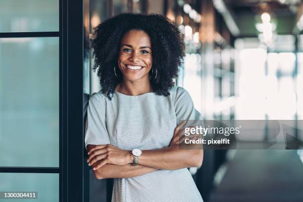hermosa mujer de negocios de etnia africana sonriente - una sola mujer fotografías e imágenes de stock