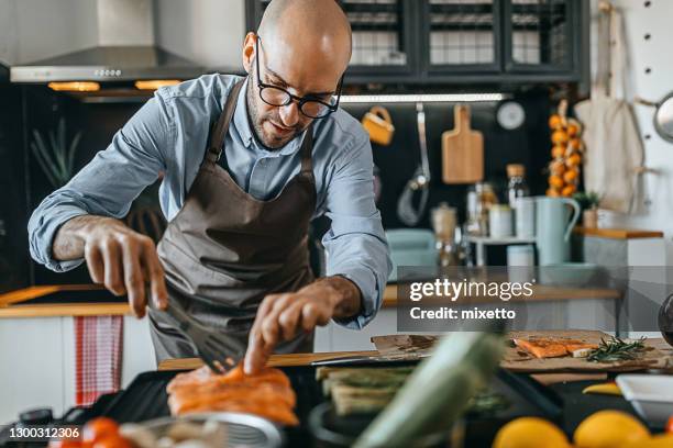 young man roasting salmon steaks and asparagus on an electric grill - bbq avocado imagens e fotografias de stock