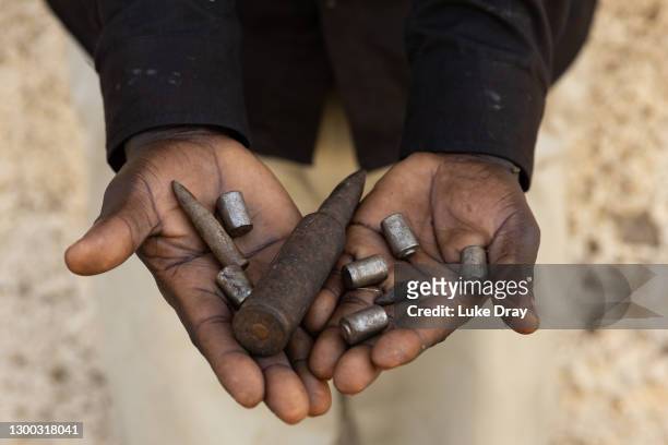 Member of the community holds bullets found inside the IDP camp after it was attacked by the LRA in 2004, on February 04, 2021 in Lukodi, Uganda. On...