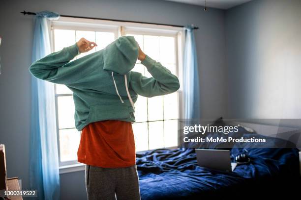 teenage boy getting dressed for school - making bed stockfoto's en -beelden