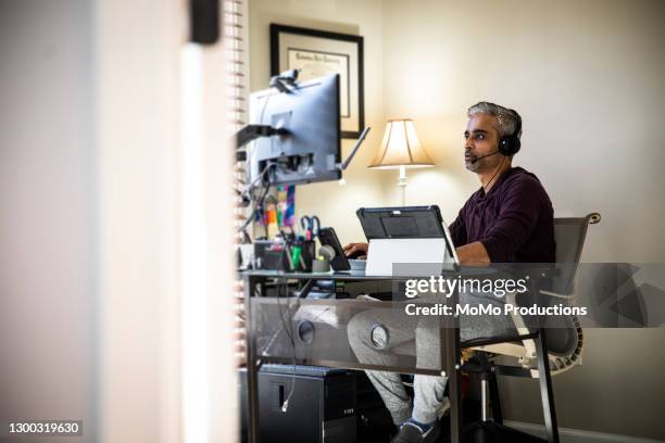 man working in home office - trading desk photos et images de collection