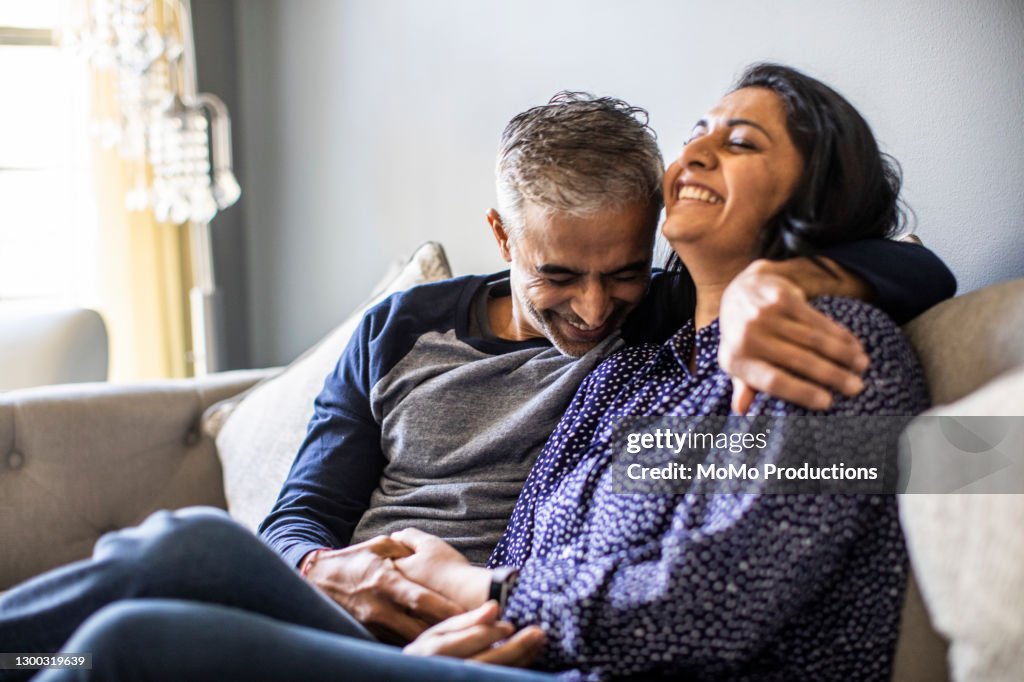 Husband and wife embracing on couch