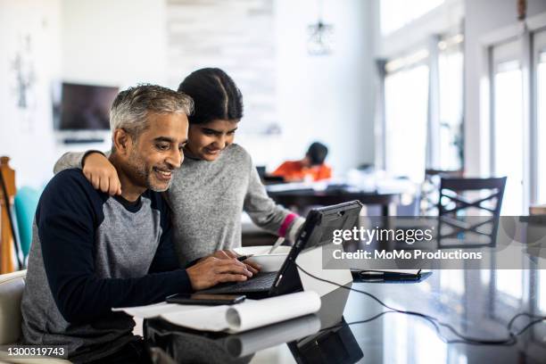 man working from home in kitchen while teenager daughter distracts him - open day 10 stockfoto's en -beelden