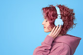 Young pink hair girl listening music in headphones