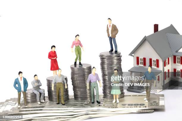 stack of coins and miniature house-concept of wealth creation - micro finance stock pictures, royalty-free photos & images