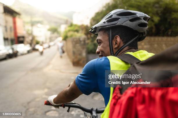 rear view of a happy delivery man on the street - road safety stock pictures, royalty-free photos & images