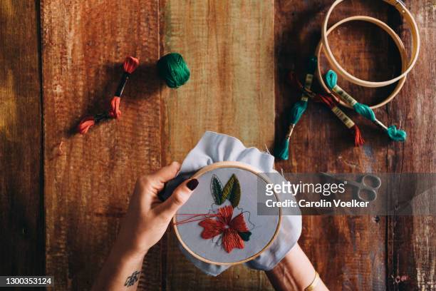 female hands with nail polish working on a piece in an embroidery hoop - embroidery frame stock pictures, royalty-free photos & images
