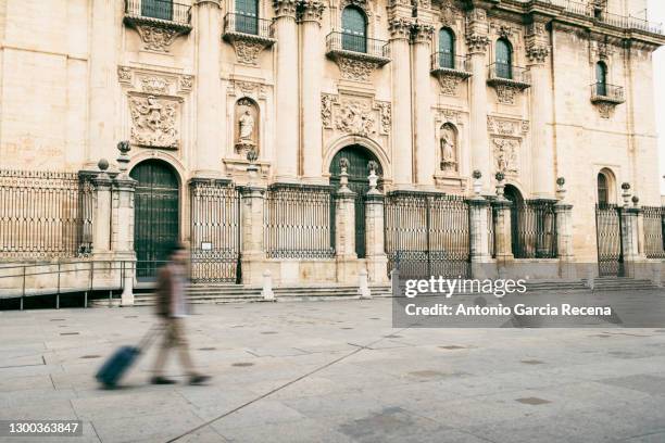 man with motion blur and suitcase walking near the cathedral. cathedral "la asuncion" - jaén city stock pictures, royalty-free photos & images