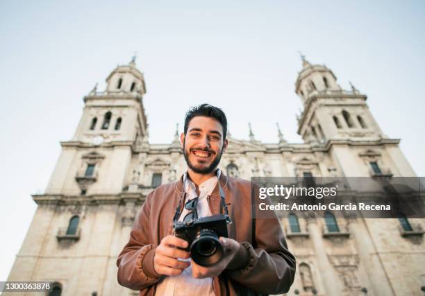 man traveling happy in europe with mirrorless camera smiling looking at the view with jaen cathedral " la asuncion " in background - jaén city stock pictures, royalty-free photos & images