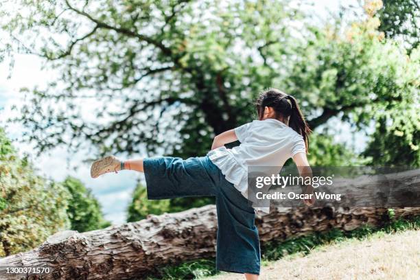 teenage girl practicing martial art in park - hong kong lifestyle society health stock pictures, royalty-free photos & images