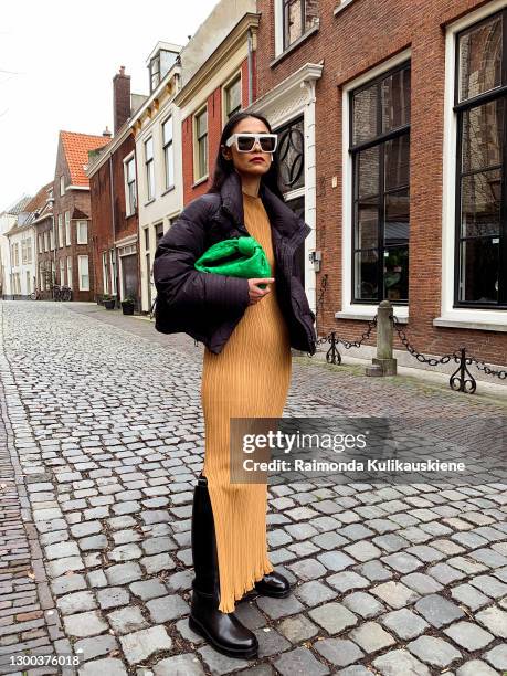 Pornwika Spiecker wearing Holzweiler dress and jacket, Ann Demeulemeester boots, Bottega Veneta bag and Celine sunglasses poses during an online...