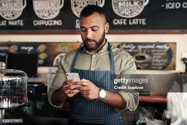 een drukke ondernemer moet verbonden blijven - african american restaurant texting stockfoto's en -beelden